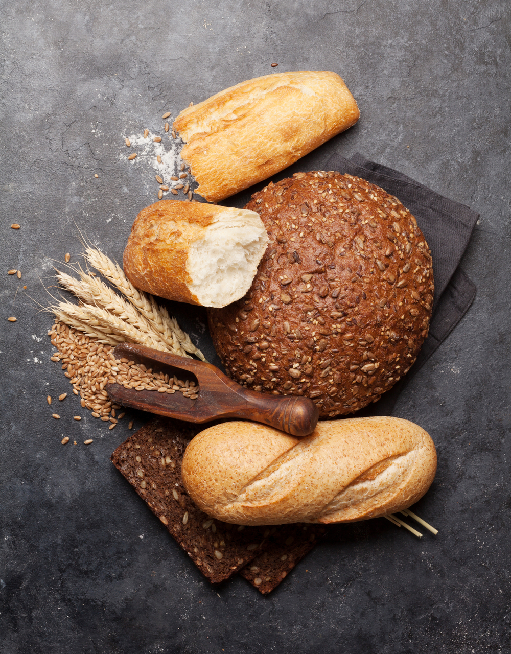 各种面包面粉和小麦放在石桌上自制烹调的概念顶视图平铺