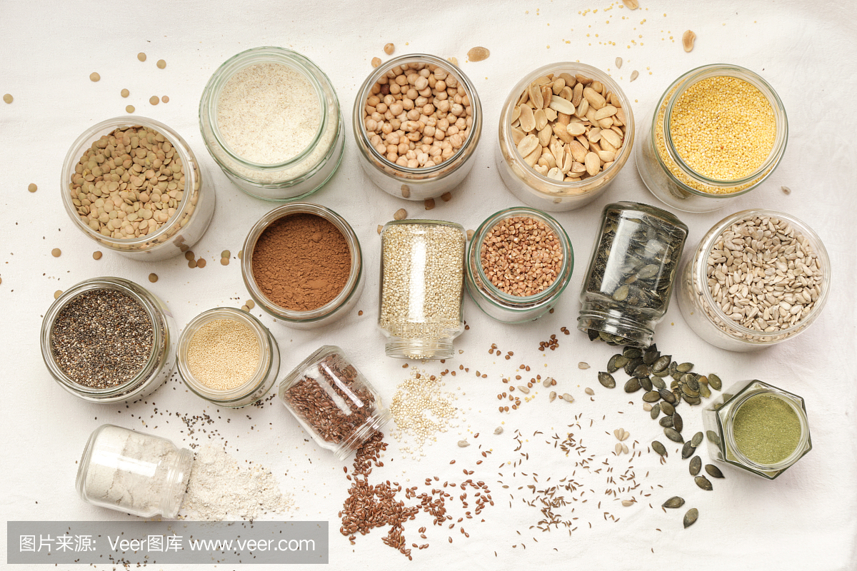 顶视图的罐子与谷物,种子,豆类,面粉和各种食物配料。健康食品的概念。
